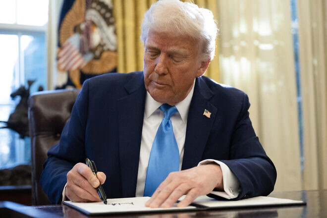 U.S. President Donald Trump signs an executive order withdrawing his country from a number of United Nations bodies in the Oval Office of the White House on Feb. 4, 2025. Photo by Andrew Caballero-Reynolds/AFP via Getty Images.