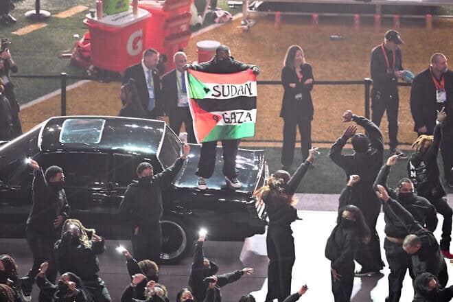 A protestor holds a Palestinian flag with the words "Gaza" and "Sudan" as U.S. rapper Kendrick Lamar performs during Super Bowl LIX Chiefs vs Eagles Apple Music Halftime Show at Caesars Superdome in New Orleans, Louisiana, Feb. 9, 2025. Photo by Chandan Khanna/AFP via Getty Images.