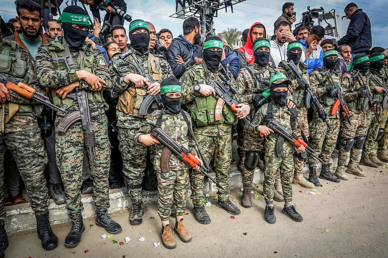 Palestinian children dressed in the Al-Qassam Brigades uniform and carrying weapons participate in a handover of Israeli hostages to the Red Cross, in Deir al-Balah, Gaza, Feb. 8, 2025. Photo by Abed Rahim Khatib/Flash90.