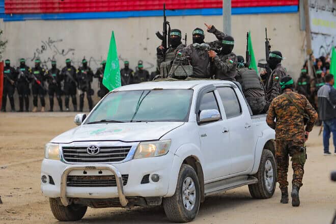 Hamas terrorists in the Al-Qassam Brigades hand over Israeli hostages to the Red Cross, as part of the ceasefire agreement between Israel and Hamas, Deir al Balah, Feb. 8, 2025. Photo by Ali Hassan/Flash90.