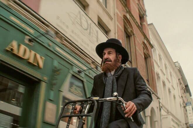 Nuchem Shtisel (played by Sasson Gabay) rides a bicycle through Amsterdam in “Kugel.” Credit: Courtesy of IZZY.