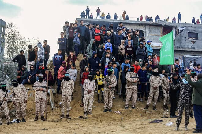 Al-Qassam Brigades terrorists and Gazan civilians waiting for the handover of the bodies of four Israeli hostages to the Red Cross in Khan Yunis, Feb. 20, 2025. Photo by Abed Rahim Khatib/Flash90.