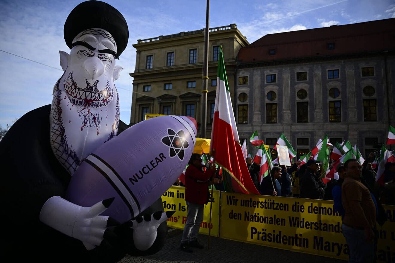 Demonstrators hold Iranian flags and a huge inflated figure representing Iran's Supreme Leader Ali Khamenei holding a nuclear bomb as they protest against the Iranian regime as a main source of war and crises in the Middle East at Odeonsplatz Square in Munich, the venue of the Munich Security Conference, Feb. 16, 2024. Photo by Tobias Schwarz/AFP via Getty Images.
