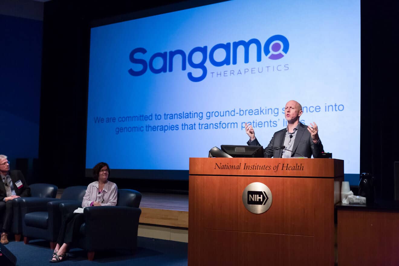 Sandy Macrae, M.B., Ch.B., Ph.D., president and CEO of Sangamo Therapeutics, speaks at Rare Disease Day at the National Institutes of Health, where Rep. Leonard Lance (R-N.J.), the House co-chair of the Rare Disease Congressional Caucus, served as a keynote speaker, March 1, 2018. Credit: Daniel Sone Photography for the National Center for Advancing Translational Sciences/Flickr via Wikimedia Commons.