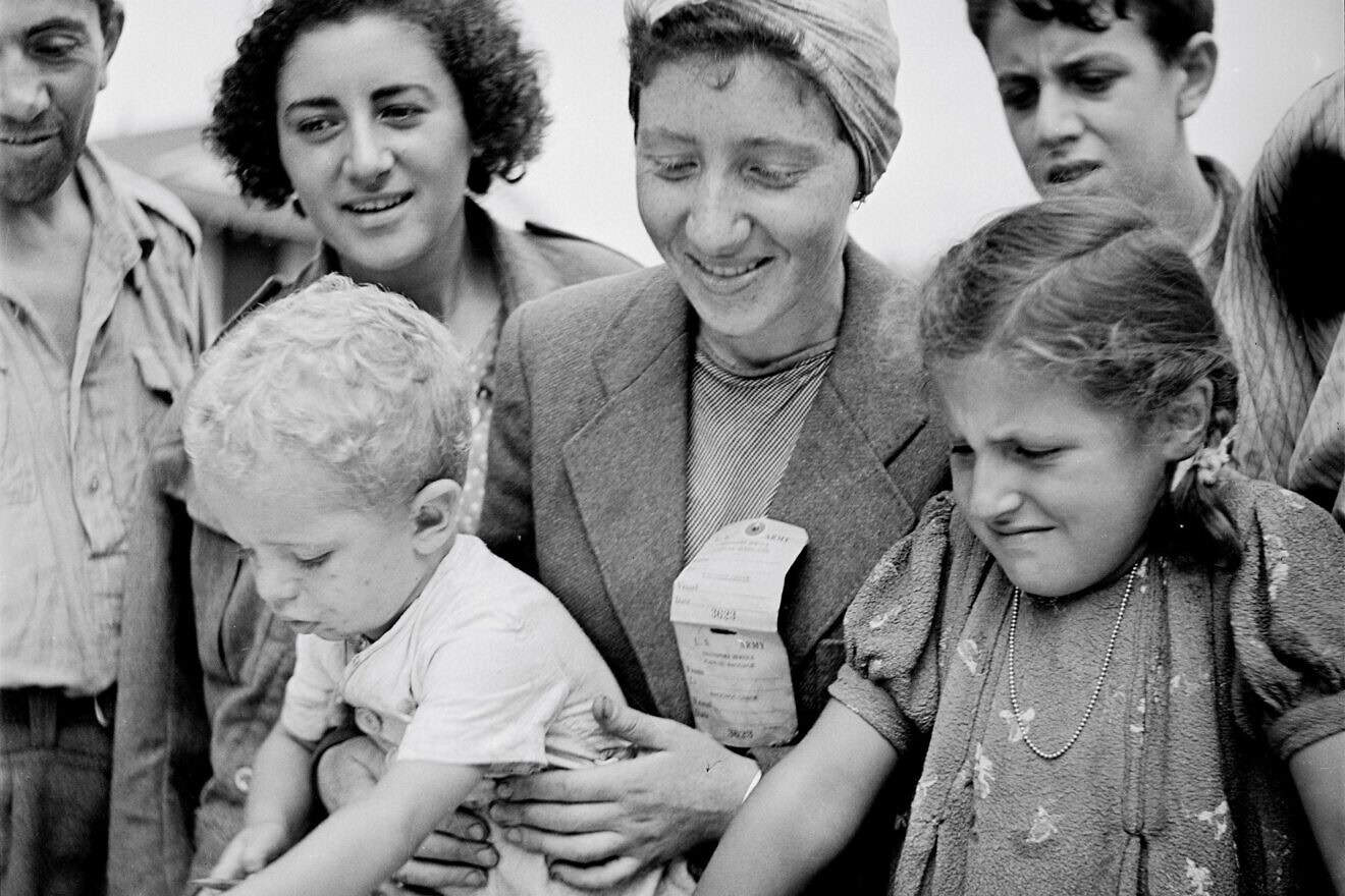 Women and children register for the Fort Ontario Refugee Camp in Oswego, N.Y., August 1944. Credit: Photographer Hikaru Iwasaki for the U.S. Department of the Interior, Public Domain, via Wikimedia Commons.