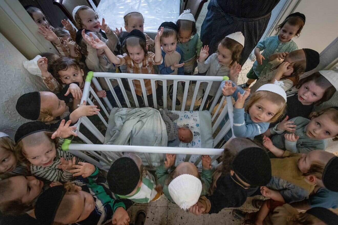 Boys in Jerusalem's ultra-Orthodox neighborhood of Mea She'arim recite the "Shema Yisrael" prayer in the presence of a week-old baby, a day before his circumcision ceremony, July 9, 2023. Photo by Chaim Goldberg/Flash90.