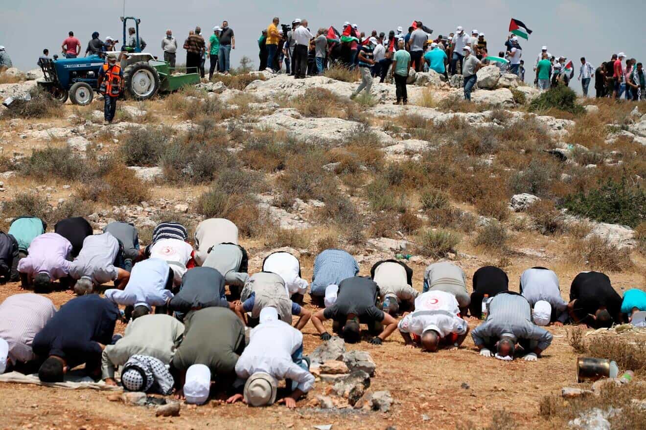 Palestinians kneel to pray during an anti-Israel protest in the town of Bidya in Samaria, on July 6, 2020. Photo by Jaafar Ashtiyeh/AFP via Getty Images.