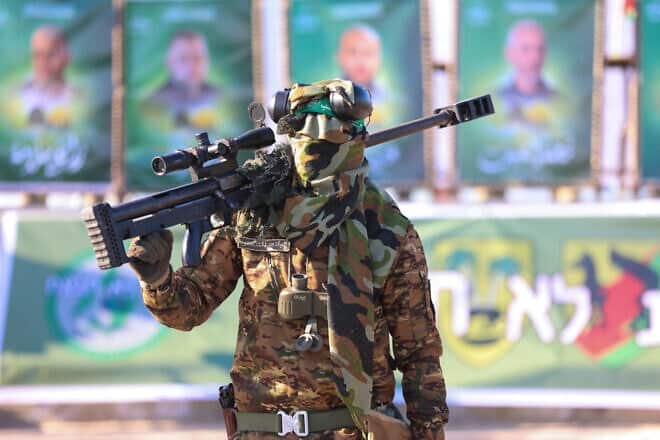 A Hamas fighter carries a sniper rifle on his shoulder as he secures an area before the handover of an Israeli-American hostage to a Red Cross team in Gaza City on Feb. 1, 2025, Photo by Omar al-Qattaa/AFP via Getty Images.