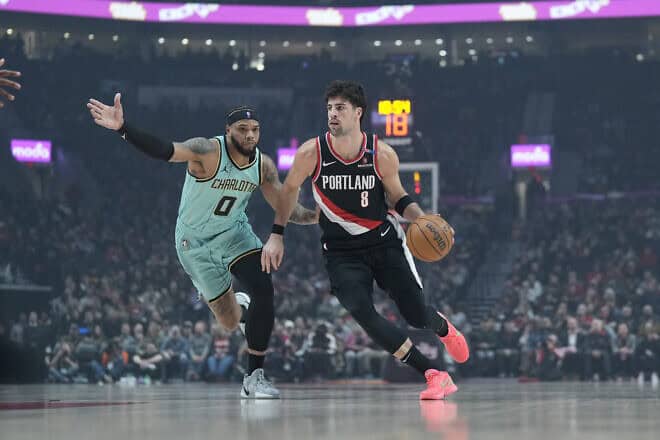Deni Avdija of the Portland Trail Blazers dribbles the ball against Miles Bridges of the Charlotte Hornets during the first half at Moda Center in Portland, Ore., on Feb. 22, 2025. Photo by Soobum Im/Getty Images.