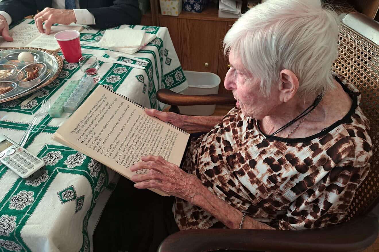 A JBI Library patron reads from a large print haggadah at her family Passover seder. Credit: Courtesy of JBI Library.