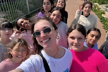 Madison Stock, 22, of Woodbury, N.Y. (center), is officially the 10,000th participant in Birthright Israel’s volunteer program. Credit: Birthright Israel.