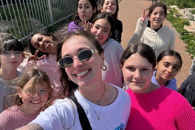 Madison Stock, 22, of Woodbury, N.Y. (center), is officially the 10,000th participant in Birthright Israel’s volunteer program. Credit: Birthright Israel.
