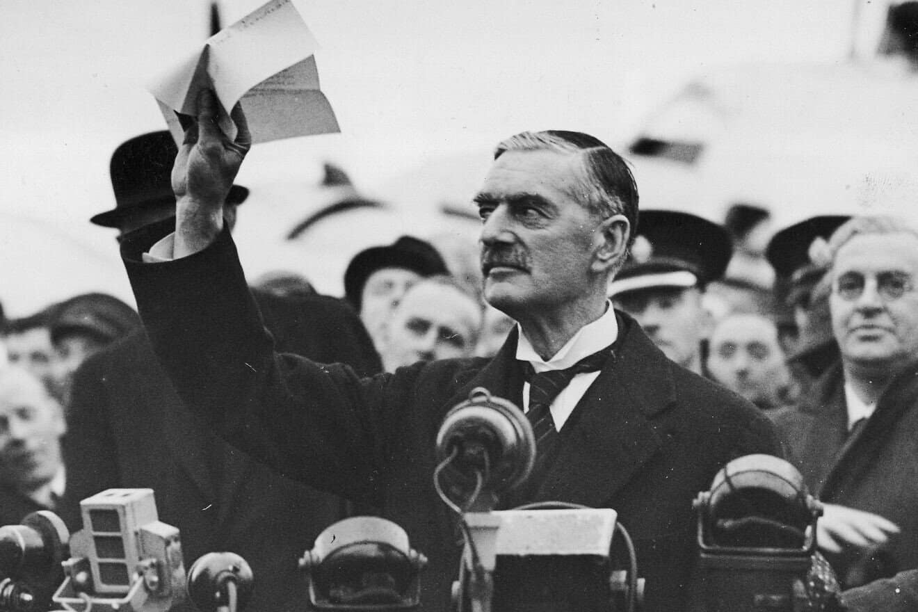 Neville Chamberlain shows off the Munich Agreement signed by Adolf Hitler on Sept. 30, 1938. Credit: The National Archive of Poland via Wikimedia Commons.