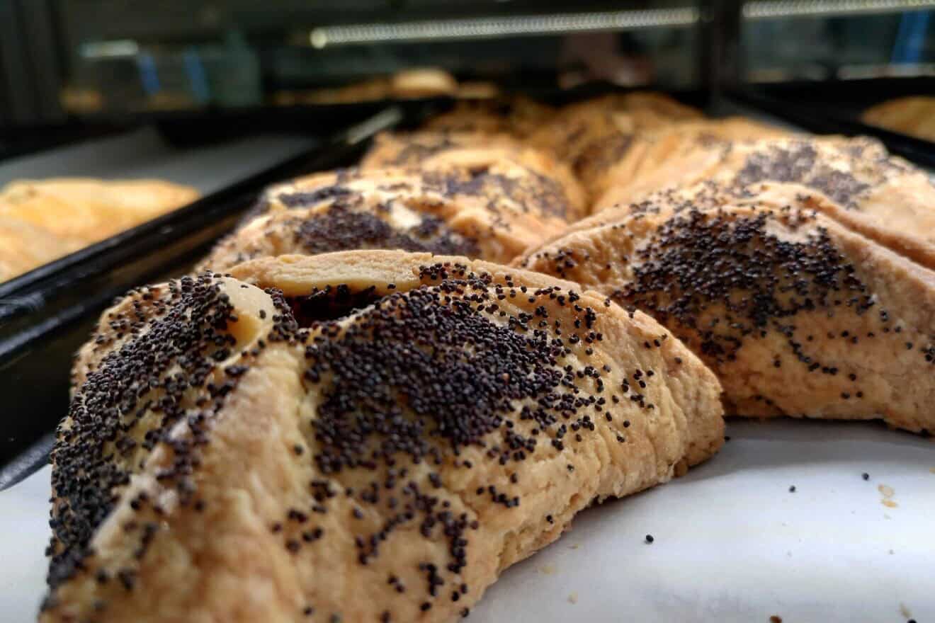 Poppy-seed hamantashen at Famous 4th Street Deli in Philadelphia, established in 1923. General manager Lou Novak says the dairy version is made with “lots of butter,” sprinkled with poppy seeds on the top and sides using even more butter, March 2, 2025. Photo by Carin M. Smilk.