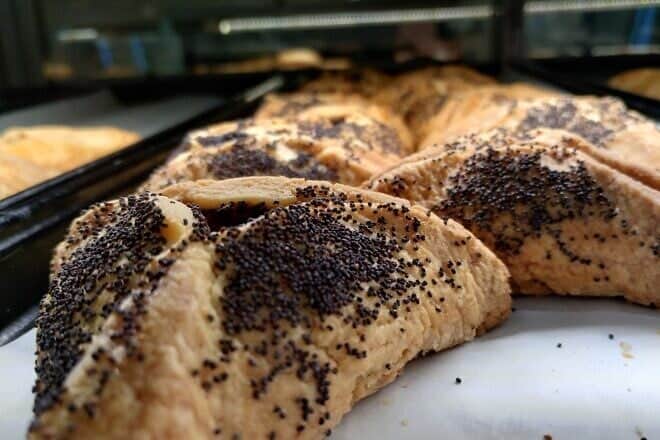 Poppy-seed hamantashen at Famous 4th Street Deli in Philadelphia, established in 1923. General manager Lou Novak says the dairy version is made with “lots of butter,” sprinkled with poppy seeds on the top and sides using even more butter, March 2, 2025. Photo by Carin M. Smilk.