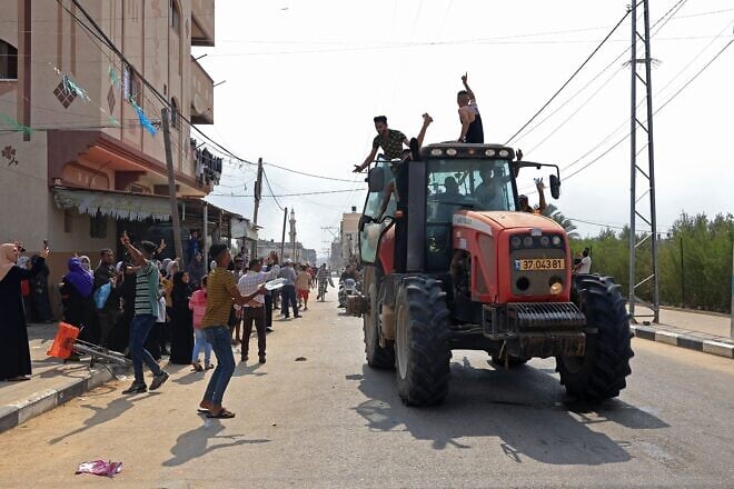 Palestinians drive an Israeli tractor that was seized after crossing the border fence with Israel from Khan Yunis in the southern Gaza Strip on Oct. 7, 2023. Photo by Said Khatib/AFP via Getty Images.