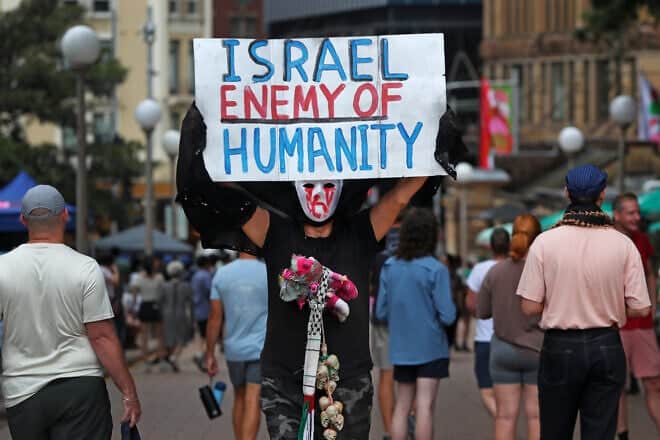 A pro-Palestinian activist holds a placard during a rally in Hyde Park in Sydney, Australia, on Dec. 8, 2024. Photo by Lisa Maree Williams/Getty Images.