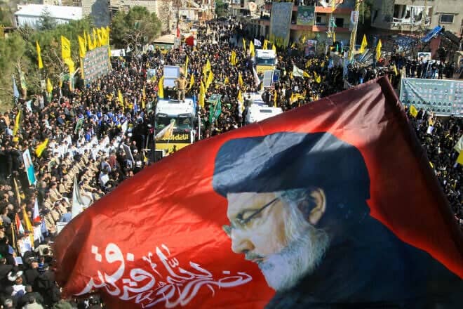A banner bearing a portrait of slain Hezbollah chief Hassan Nasrallah waves during a funeral of terrorists in the southern Lebanese border town of Aitaroun, Feb. 28, 2025. Photo by Mahmoud Zayyat/AFP via Getty Images.