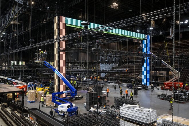 Employees work under an element of the stage during a press visit at the St. Jakobshalle multi-purpose indoor arena that will host the 2025 Eurovision Song Contest, in Basel, Switzerland, April 15, 2025. Photo by Fabrice Coffrini/AFP via Getty Images.