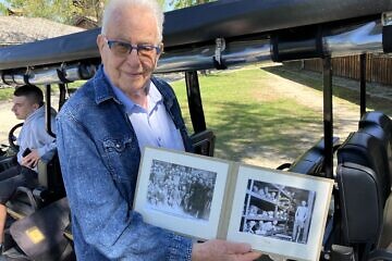 Naftali Furst holds a photo of himself as a boy in Auschwitz, April 23, 2025. Photo by Etgar Lefkovits.