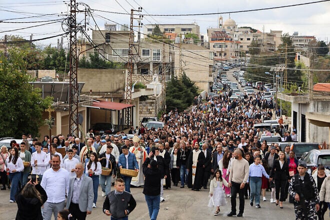 Residents and members of the clergy march together ahead of Palm Sunday mass in Lebanon's southern village of Qlayaa on April 13, 2025. Photo by Rabih Daher/AFP via Getty Images.