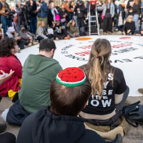 Jews and supporters hold a Passover seder  in Brooklyn, N.Y., near the home of Sen. Chuck Schumer (D-N.Y.), to protest Israel's war with Hamas in Gaza, prompted by the massacre on Oct. 7, 2023, of 1,200 people and the kidnapping of 251 others in southern Israel, April 23, 2024. Photo by Spencer Platt/Getty Images.