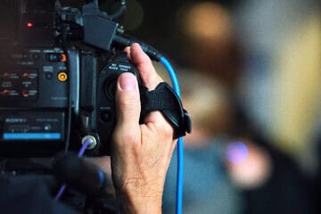 A press videographer films a press conference in the Hennepin County Government Center in Minneapolis. Credit: Tony Webster via Wikimedia Commons.
